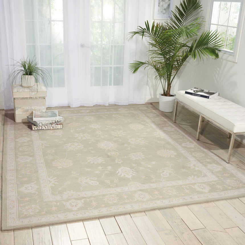 Light-filled room with a Nourison Zephyr Silver rug, white bench, sheer curtains, and wood floors.