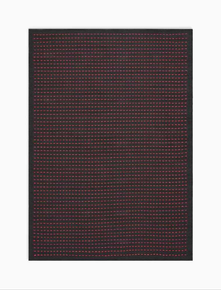 Close-up of the Calvin Klein Seattle Black Magenta rug, featuring a grid pattern of magenta dots on a black background.