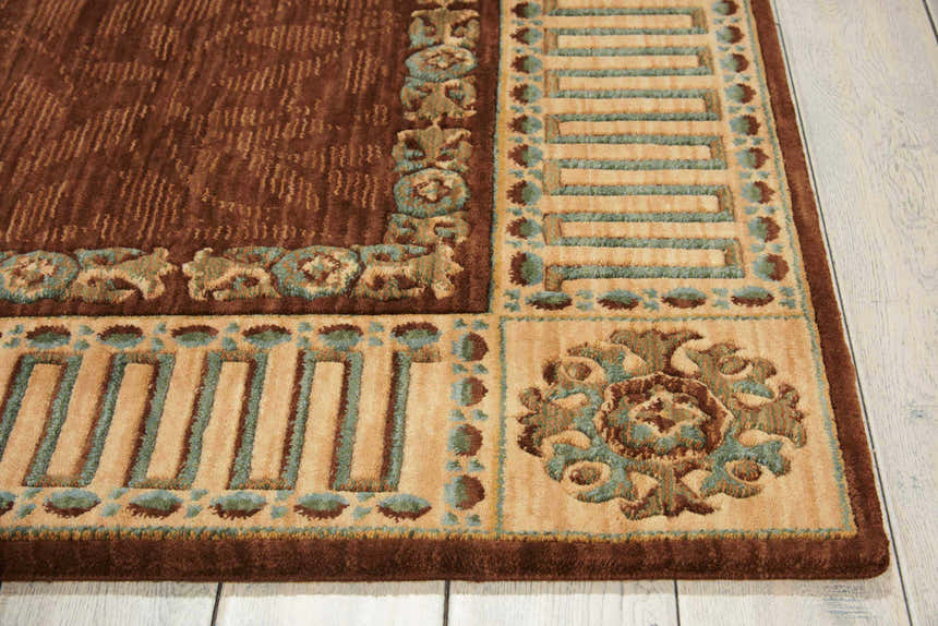 Close up of the vintage Nourison Vallencierre Brown rug, showcasing its dark brown, tan, and teal floral and geometric border pattern.
