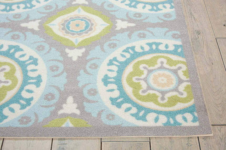 Close-up of the Waverly Sun N' Shade Jade rug. Features a coastal-inspired medallion pattern in jade, blue, grey, and white.