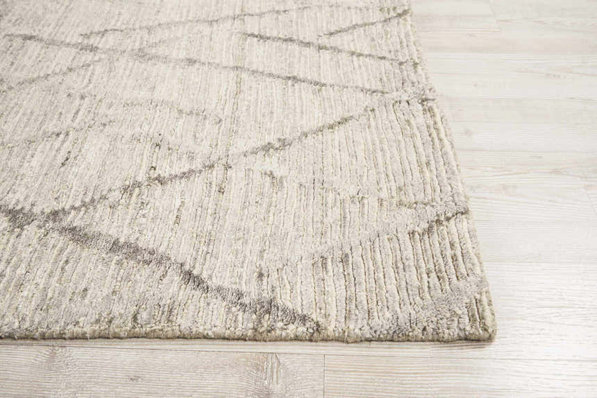 Close-up of the Nourison OCEAN Stone rug showing its chunky texture and sandstone color on wood floors.