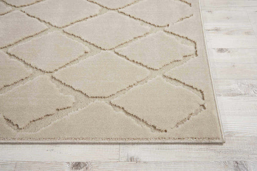 Close-up of the Michael Amini Gleam Ivory rug showing a diamond pattern and soft texture on a light wood floor.