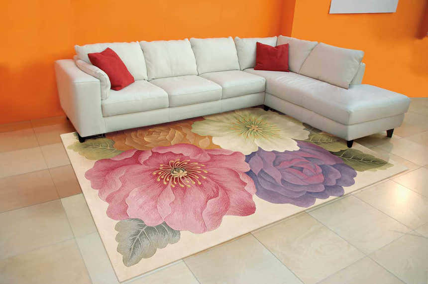 Living room with white sofa and Nourison Tropics Multicolor rug featuring large floral designs in pink, purple, and yellow.