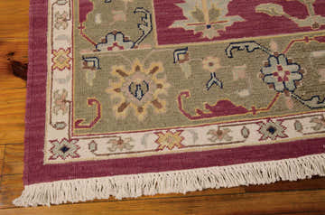 Close up of the Nourison Nourmak Burgundy rug showing wool texture, fringe, and traditional floral pattern.