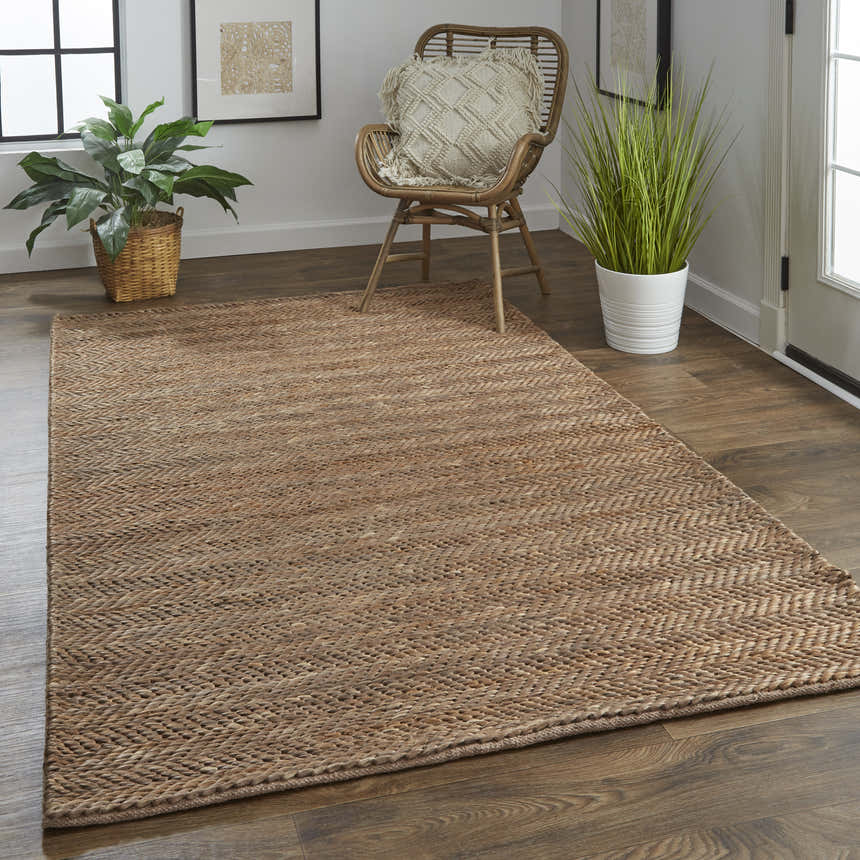 Entryway with Feizy Kaelani brown jute rug, wood floors, rattan chair, and potted plants for a natural, transitional style. Roomscene-Rectangle