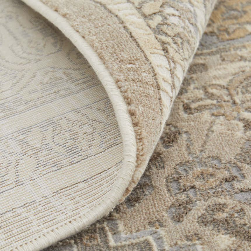 Close-up of the Feizy Celene Tan/Brown/Ivory Area Rug showing its traditional medallion pattern and soft, textured pile. Fold