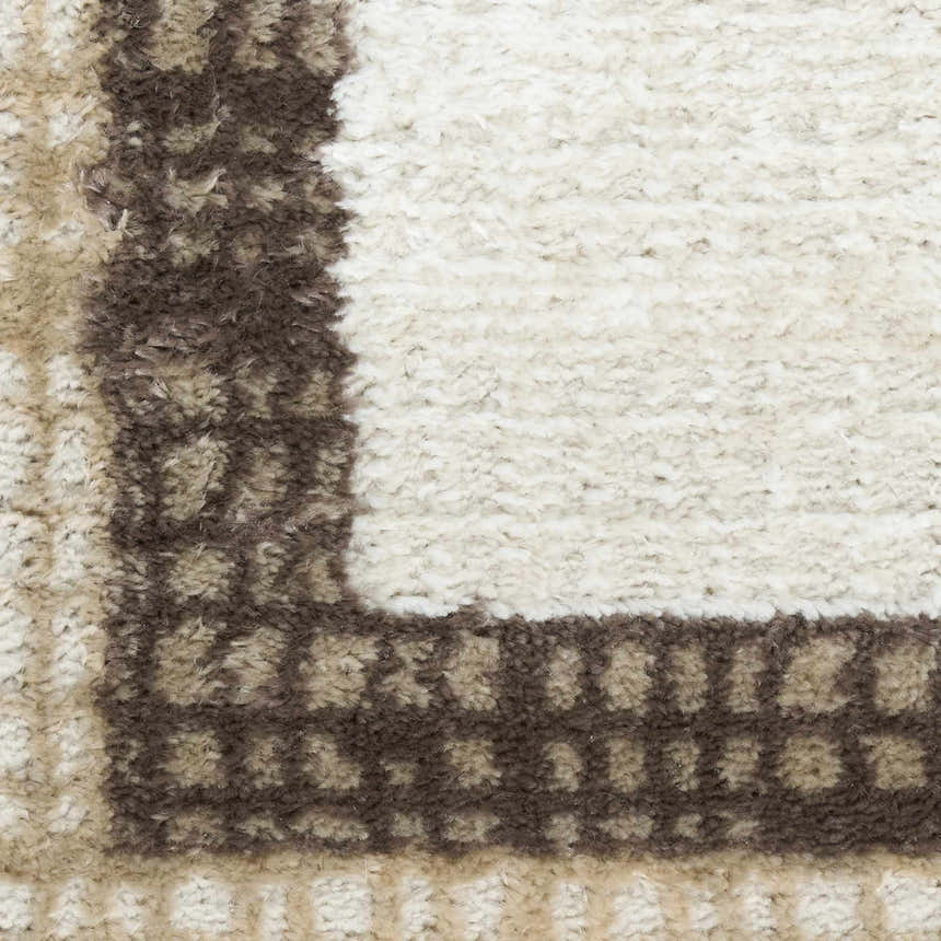 Close-up of the high-pile Nourison Dekor Ivory Brown rug, showing the chestnut border and soft ivory center.
