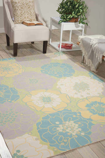 Living room scene with the Nourison Home & Garden Green Contemporary Area Rug, featuring blue, yellow, and white floral pattern.