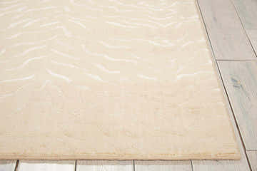 Close-up of the Nourison Nepal Bone Vintage rug showing its beige color and subtle, flowing pattern on light hardwood floors.