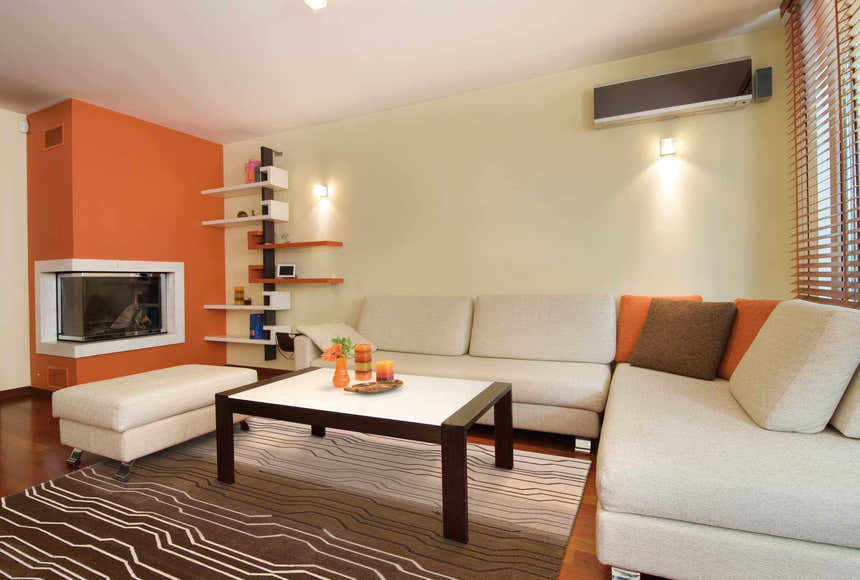 Eclectic living room with a Nourison Contour Natural rug, cream sofa, and orange accent wall.