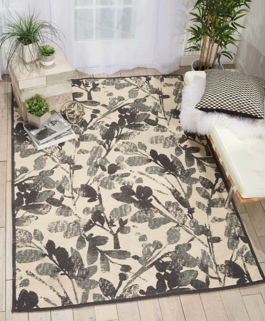 Light-filled room with Waverly Vintage Lux Graphite rug, white daybed, wood floors, and plants. Modern, airy feel.