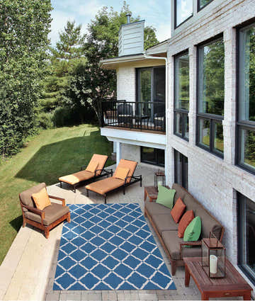 Outdoor patio scene with lounge chairs and Nourison Home & Garden Navy Contemporary Area Rug.