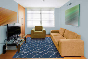 Living room scene with a Nourison Contour Denim rug, tan sofa, and olive armchair on a wood floor.