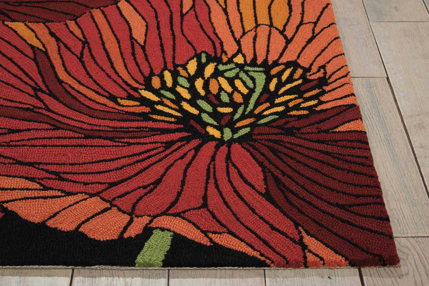 Close-up of the Nourison Fantasy Black rug, showcasing a large floral design in red, orange, and black hues.