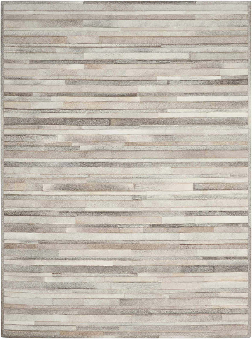 Close-up of the Calvin Klein Home Prairie Silver rug. Handmade, hair-on-hide rug with horizontal stripes in gray and silver tones.