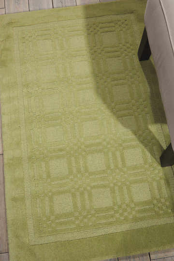 Close up of the lime green Nourison Westport rug with a geometric pattern and plush wool texture.