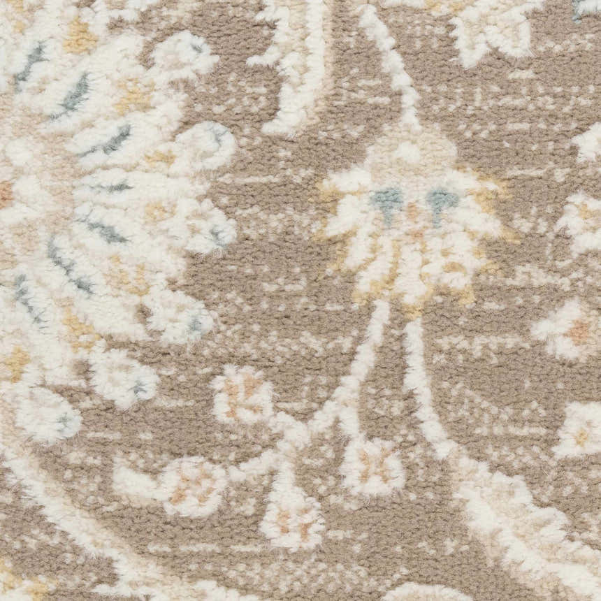 Close-up of Nourison Isla Mocha vintage rug texture. Light brown, cream, and subtle blue floral pattern. High pile.