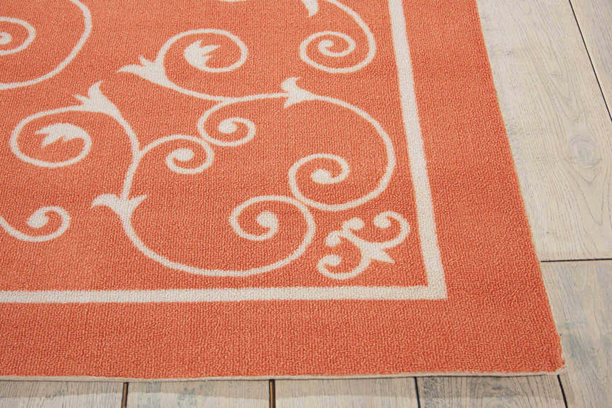 Close-up of the Nourison Home & Garden Orange Transitional Area Rug showing burnt orange color and white floral scroll pattern.