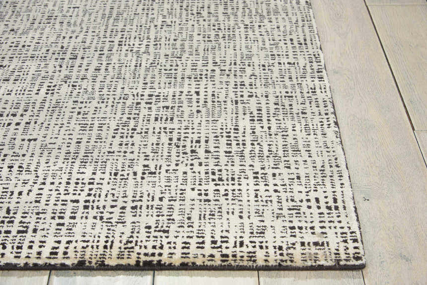 Close-up of Nourison Starlight Midnight rug showing the abstract black and white pattern and luxcelle texture.