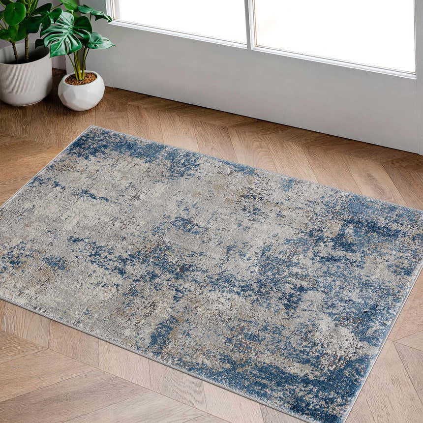 Sapcote Textured Luxe Area Rug in a bright room with wood floors and potted plants. Blue, beige, and gray abstract pattern. Roomscene-Rectangle