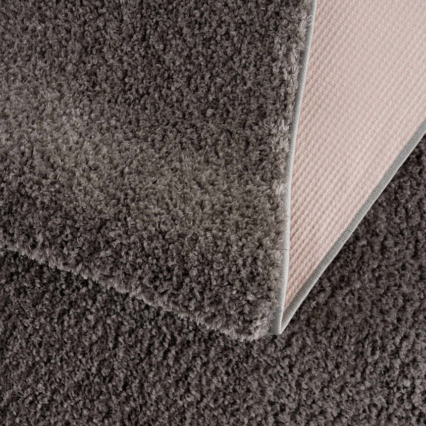 Close-up of the Judy Solid Dark Gray Washable Shag Rug showing its plush texture and durable backing. Fold