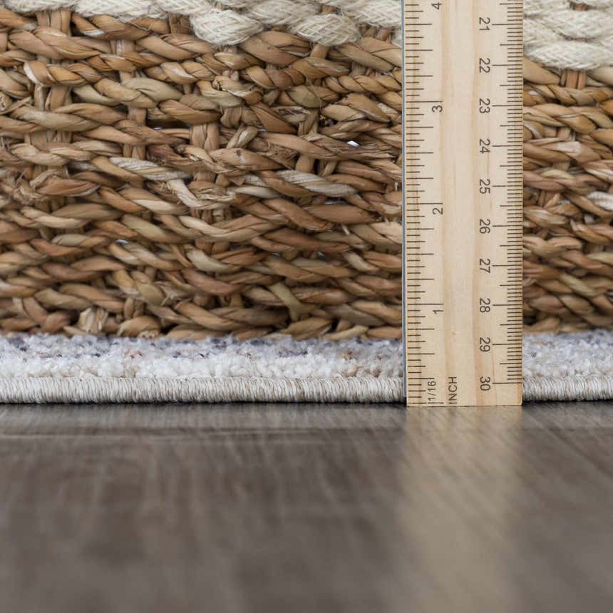 Close-up of the Lapis Area Rug showing pile height with a ruler. Light gray rug with natural gray accents. Pile