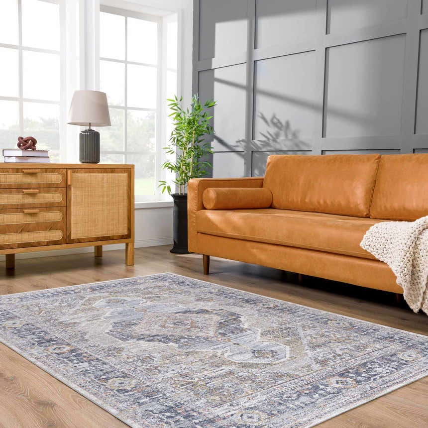 Living room scene with a light gray Lapis Area Rug, tan leather sofa, and wood cabinet. Roomscene-Rectangle