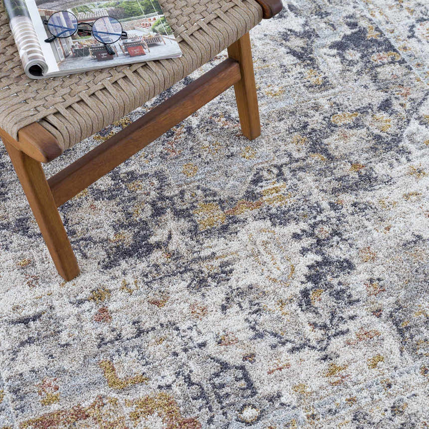 Close-up of the Ivria Navy & Rust Area Rug, showing light gray, natural gray, navy, and rust colors. Abstract pattern. Styleshot