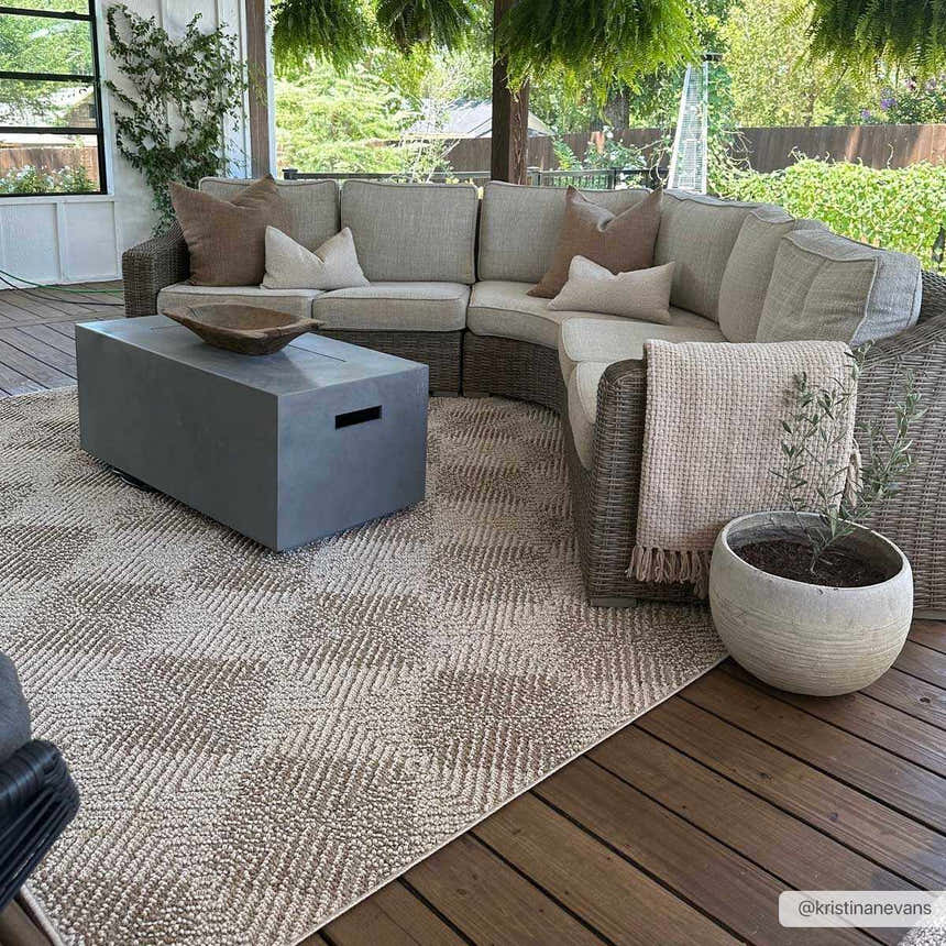 Outdoor patio with gray sectional, concrete table, and Broox Beige Area Rug. Roomscene-Rectangle