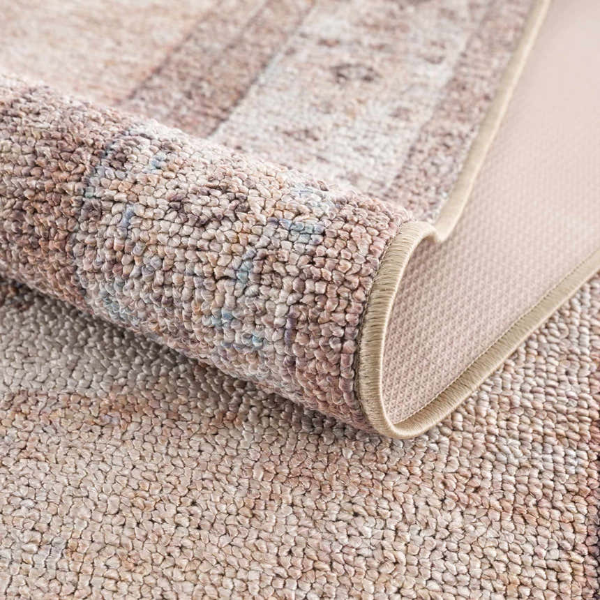 Close-up of the tan Analu Non-Slip Washable Rug showing its texture, non-slip backing, and rolled edge. Fold