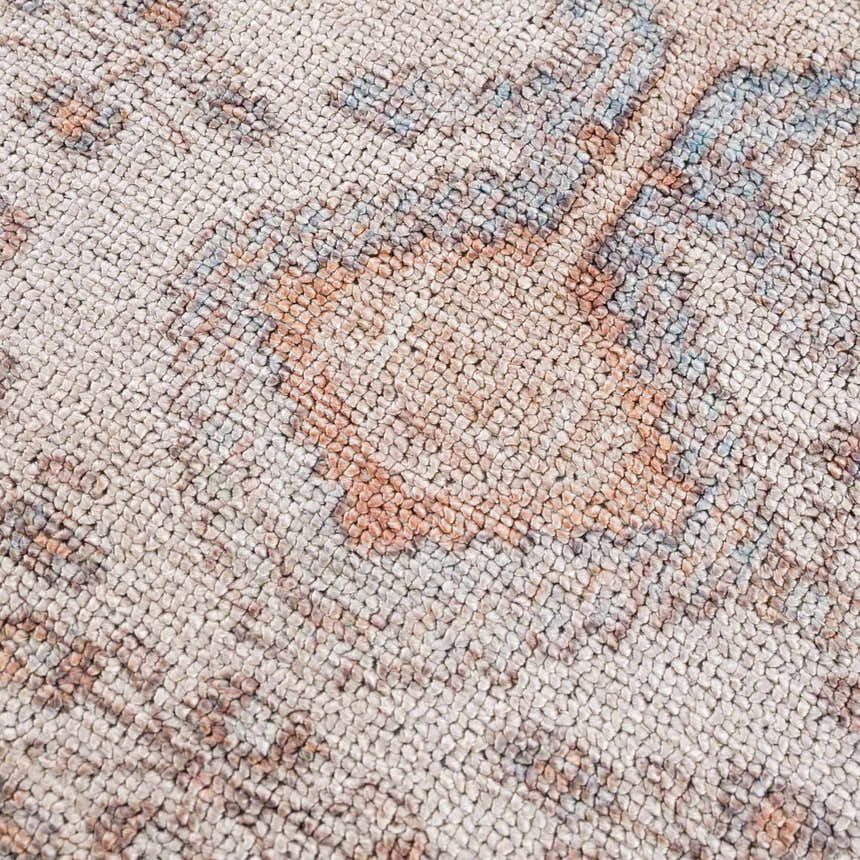 Close up of the Analu Non-Slip Washable Rug showing the traditional pattern in brown, tan, light blue, and dark red. Texture