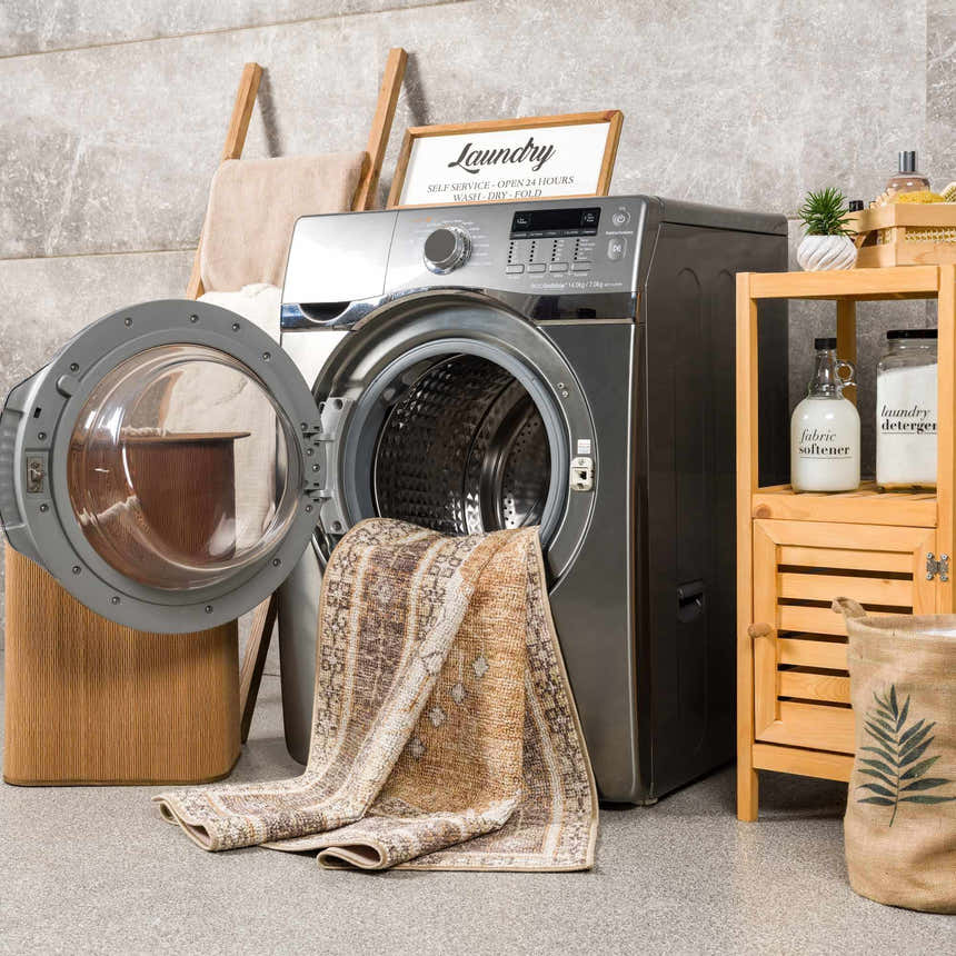 Laundry room scene with Albas Washable Area Rug partially in the washing machine, showcasing its easy-clean feature. Washing-Machine
