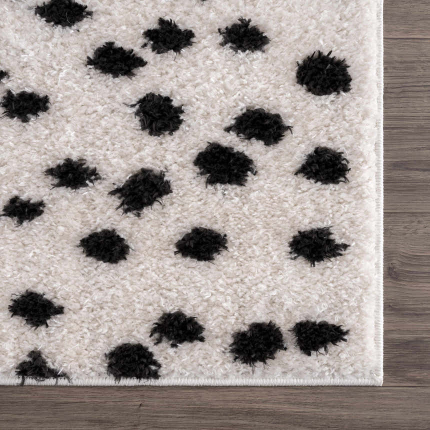Close up of the Cansu Black & White Dotted Area Rug. Shag rug with black dots on off-white background. Swatch