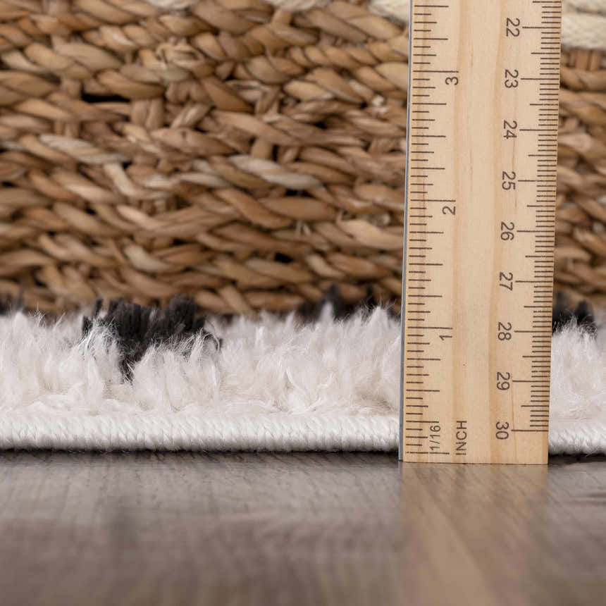 Close-up of the plush texture and pile height of the Cansu Black & White Dotted Area Rug with a ruler for scale. Pile