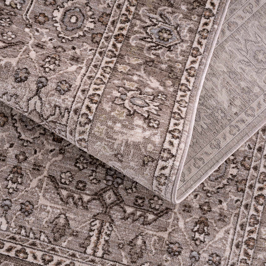 Close-up of the Lugo Luxe Area Rug showing its traditional, oriental pattern and soft charcoal and light gray colors. Fold