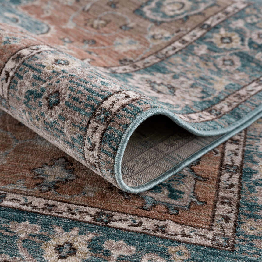 Close-up of the Edremit Area Rug - Clearance, showing its traditional oriental pattern and colors: cream, dark blue, and dusty pink. Fold