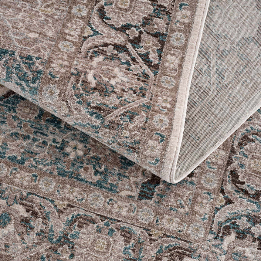Close-up of the Baychester Area Rug. Features a traditional, oriental design in cream, brown, and denim blue hues. Fold
