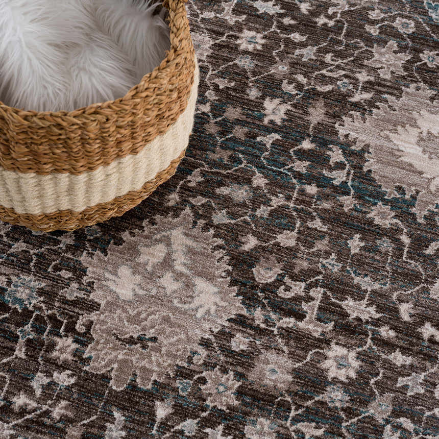 Close-up of the Linmansangan Area Rug in dark brown, ivory, and pale blue with a traditional floral pattern and woven texture. Styleshot