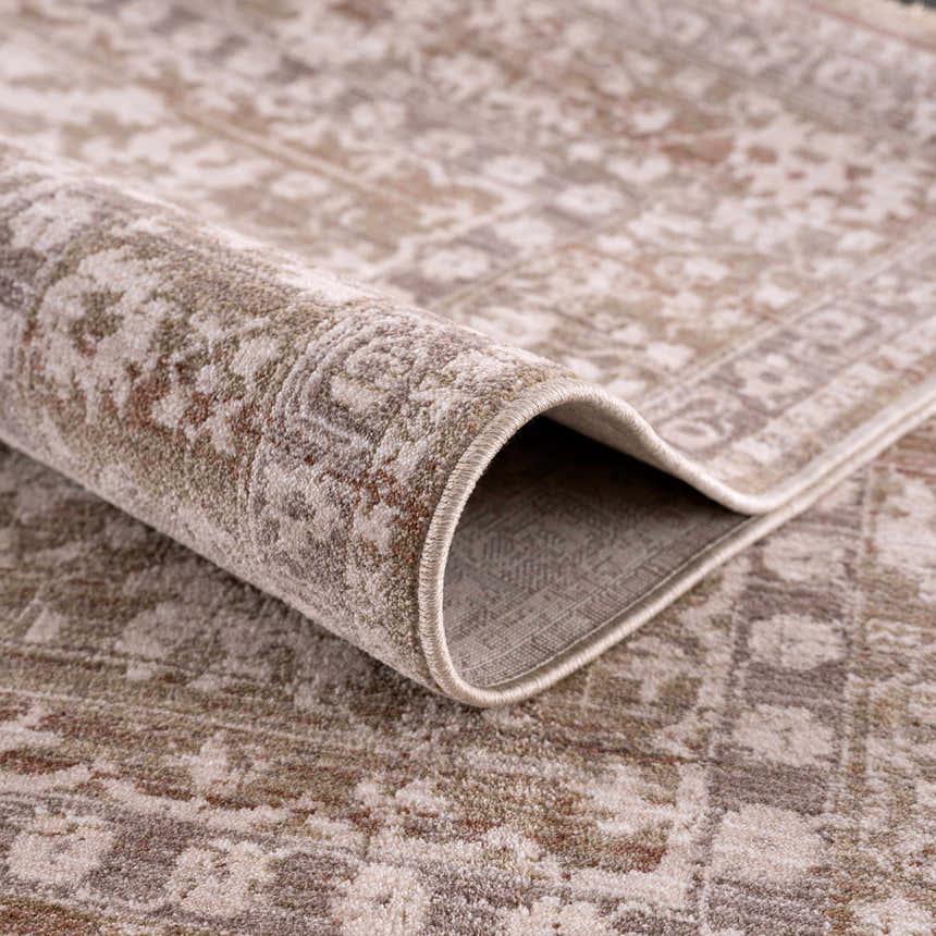Close-up of the Kaongkod Area Rug, showing its traditional, oriental design in dusty pink, ivory, and brown polyester. Fold