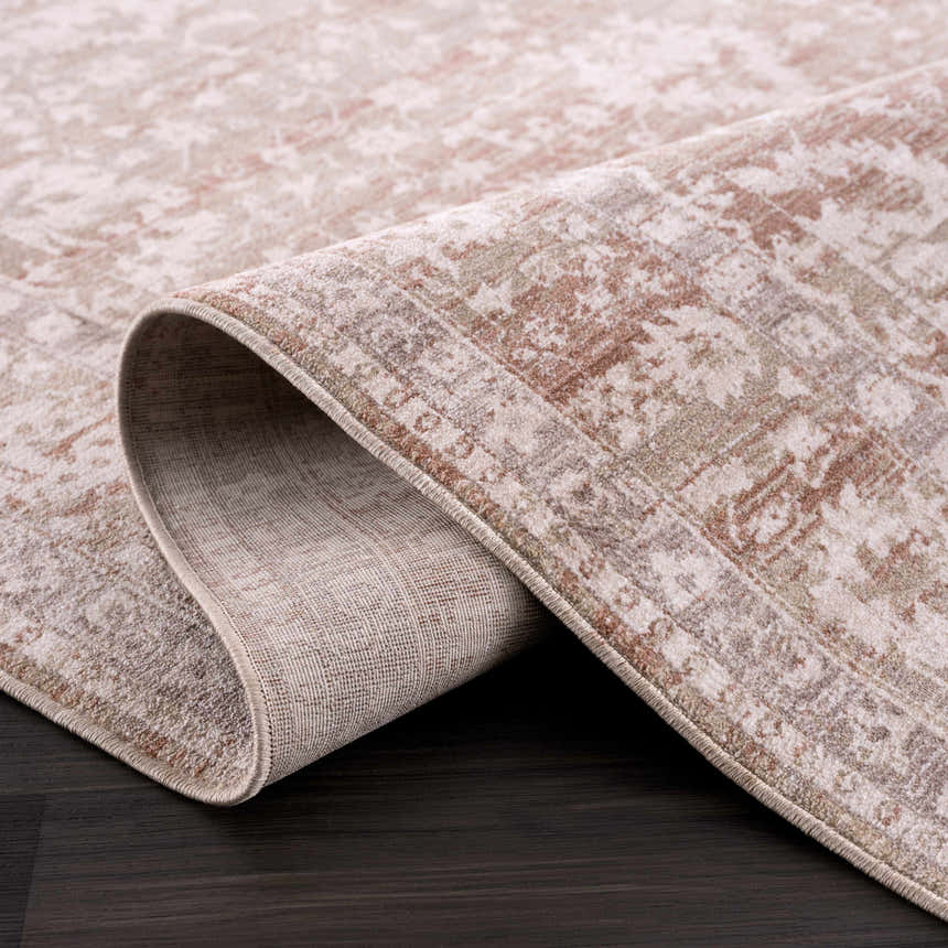 Close-up of the Kaongkod Area Rug. Dusty pink, ivory, and brown farmhouse style rug with traditional oriental pattern. Fold