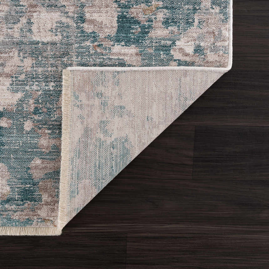 Close-up of the Danlugan Area Rug showing its charcoal, cream, and blue contemporary pattern and polyester texture. Fold