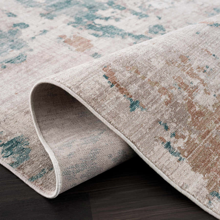 Close-up of the Danlugan Area Rug showing its cream, charcoal, dusty pink, and pale blue contemporary design. Fold