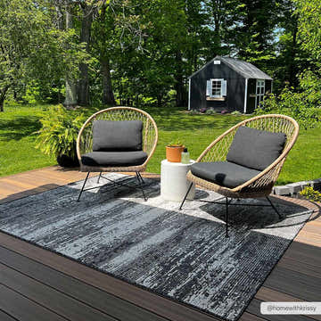 Outdoor deck scene with wicker chairs and gray Cline Brown & Gray Area Rug. Roomscene-Rectangle