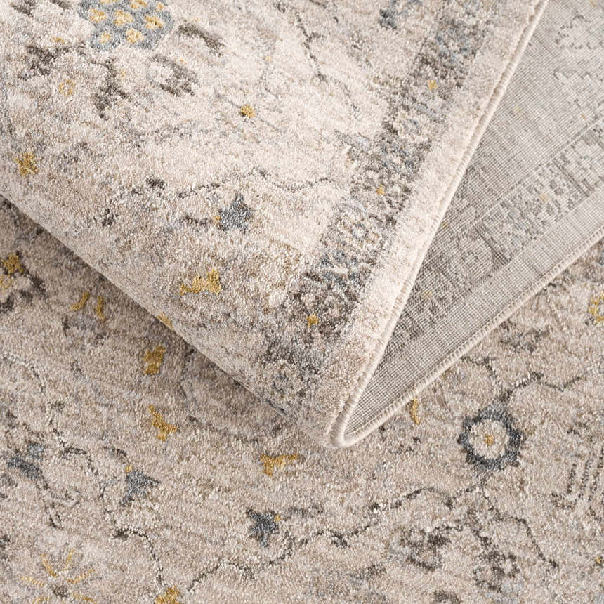 Close-up of the Annie Cream Textured Rug. Features a farmhouse style pattern in cream, gray, and gold tones. Fold