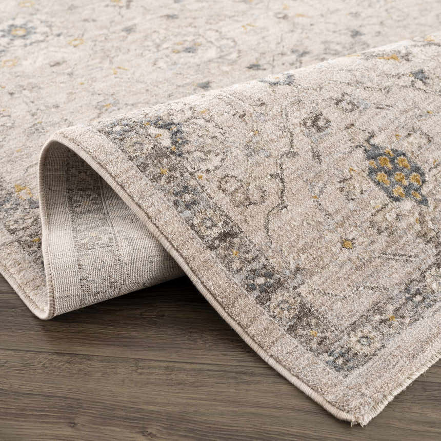 Close up of the Annie Cream Textured Rug showing its traditional pattern and soft, neutral colors. Fold