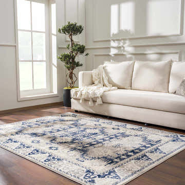 Living room scene with a Bindi Navy Area Rug, cream sofa, wood floors, and bright natural light. Roomscene-Rectangle