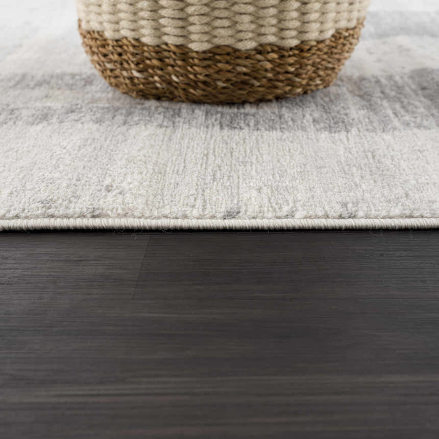 Close-up of Tigria Ivory 2316 area rug showing gray and ivory pattern, plush texture, and woven basket detail. Pile