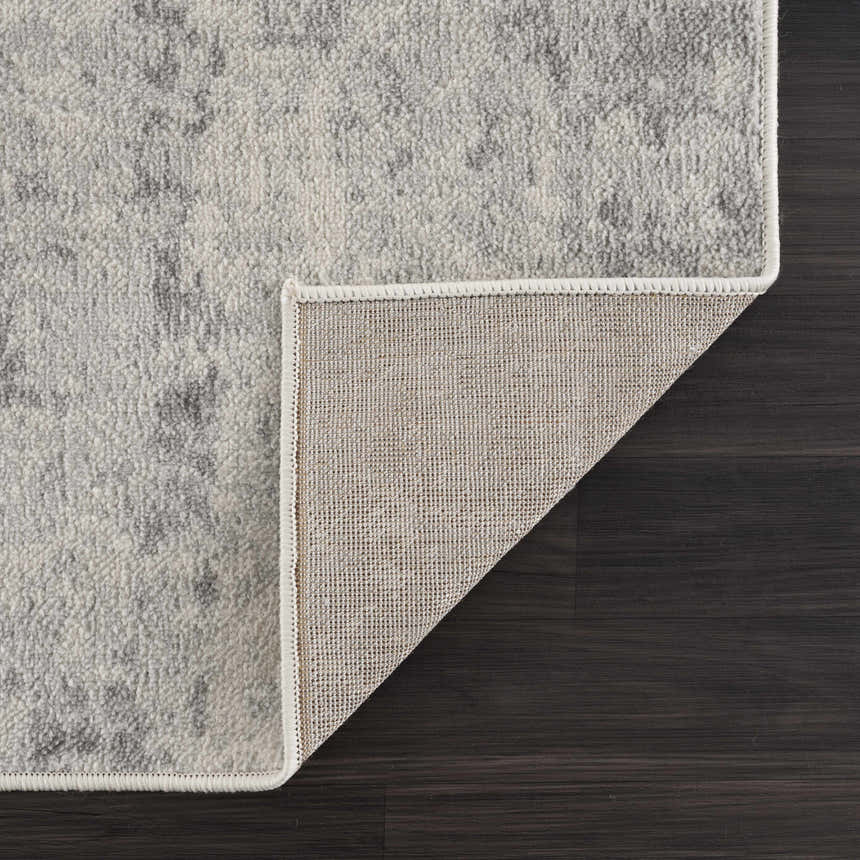 Close-up of the Tigrima Ivory 2319 area rug showing its ivory and gray contemporary pattern and durable woven backing. Fold