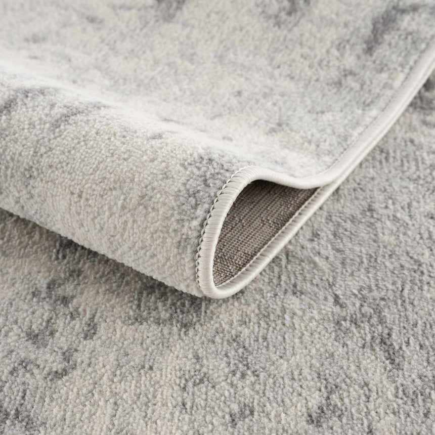 Close-up of the Tigrima Ivory 2319 area rug showing its gray and ivory contemporary pattern and soft, textured polypropylene weave. Fold