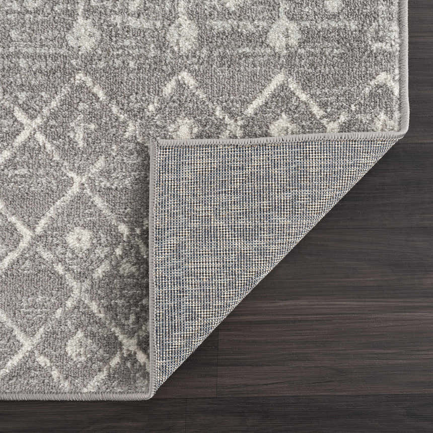 Close-up of the Marash KMRSH-4607 area rug showing its dark gray and ivory contemporary pattern and machine-made construction. Fold